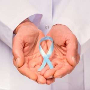 Close up of doctor hand with a blue ribbon.